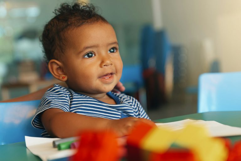 Happy baby playing with toy blocks.